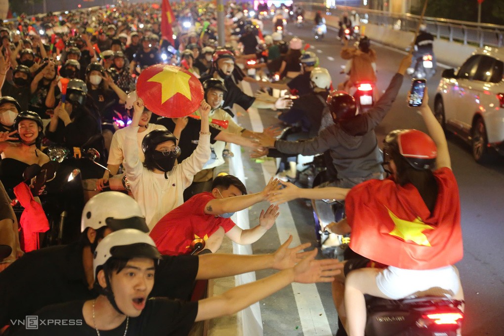 Nhiều bạn trẻ vươn mình đập tay vào dòng người lái xe máy ở làn ngược chiều khuấy động không khí. Ảnh: Đình Văn