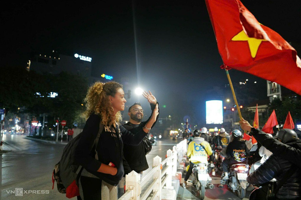 Du khách nước ngoài chia vui với người Việt Nam trên đường phố. Ảnh: Ngọc Thành