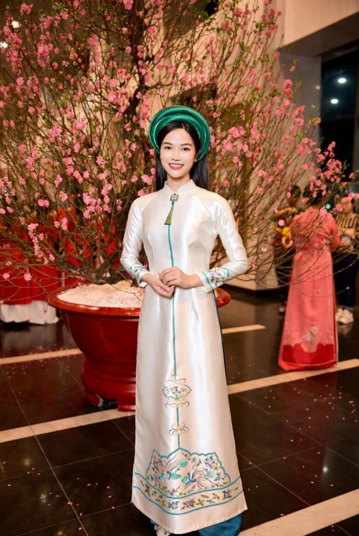 Anh Đào chọn mẫu áo dài 100% lụa tơ tằm được thêu hoa văn truyền thống, tông màu nhẹ nhàng giúp cô không bị già.