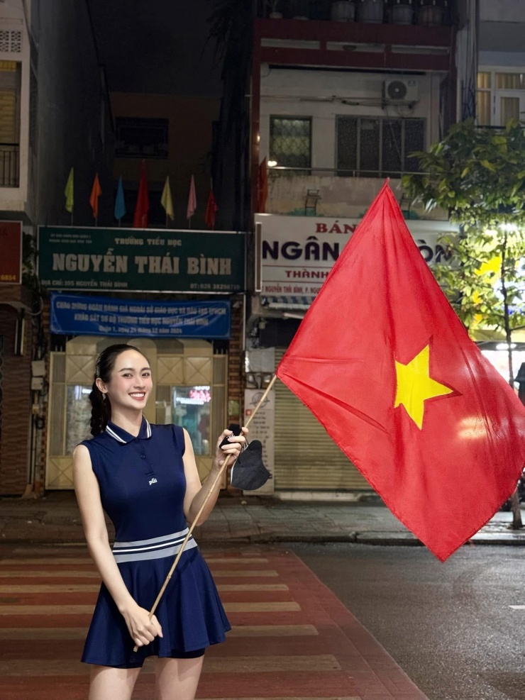 Á hậu Miss Universe Vietnam 2024 Vũ Thúy Quỳnh cầm cờ đỏ sao vàng, cổ vũ dòng người 