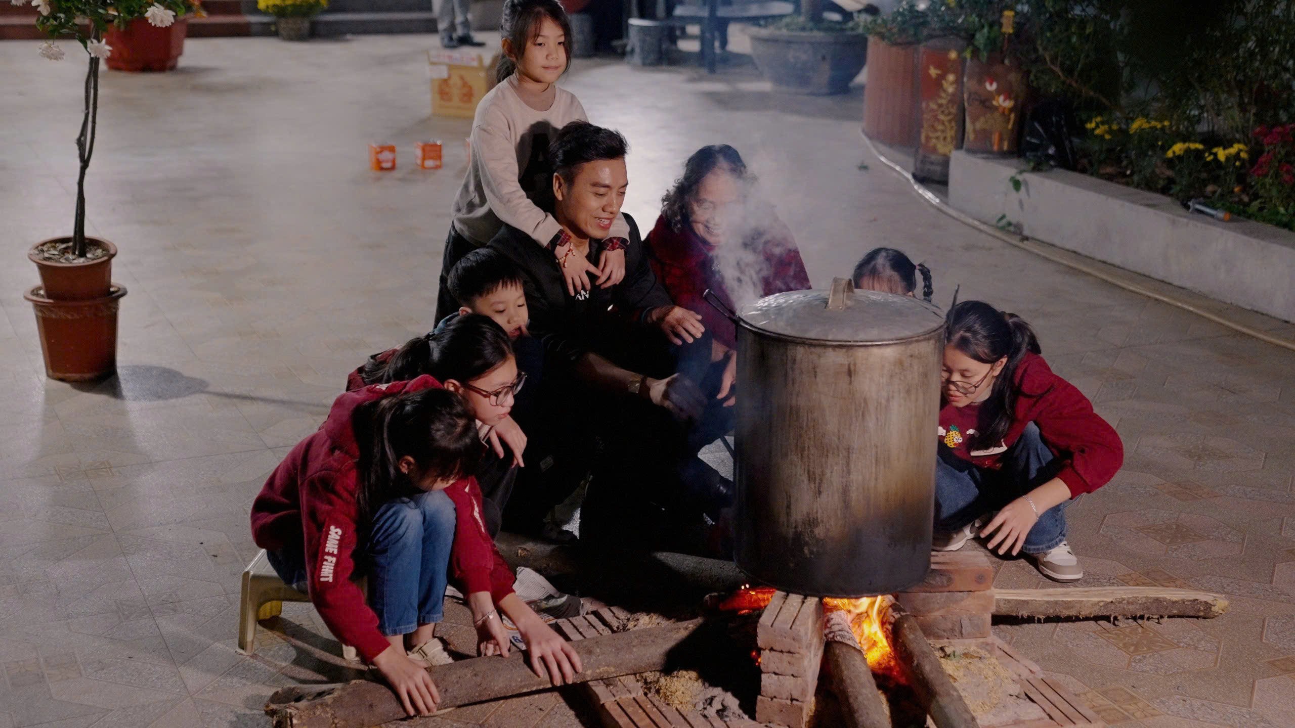 Hình ảnh đại gia đình quây quần bên nồi bánh chưng mang tới không khí ngày Tết.