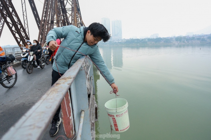 Nhiều người đã gửi gắm việc thả cá tới tay thành viên trong nhóm bằng cách đưa cá vào xô nhựa rồi thả dây từ mặt cầu Long Biên đưa xuống sát mặt nước sông Hồng.