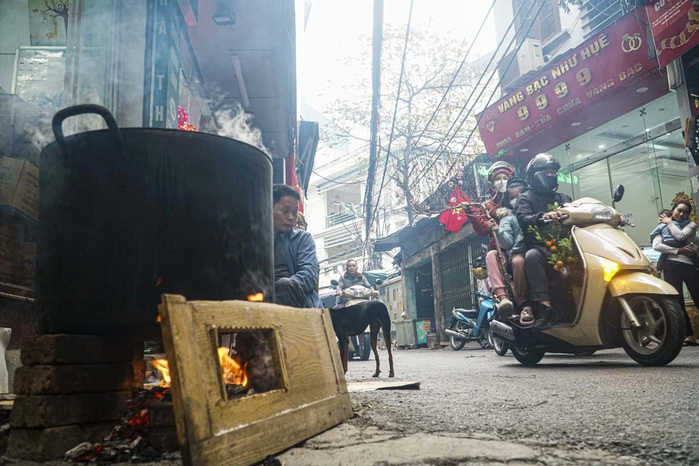 Phố phường ở Hà Nội những ngày cận Tết Nguyên đán đỏ lửa bên những nồi bánh chưng.