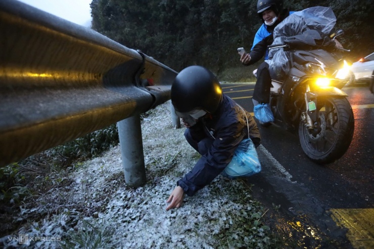 Người dân chụp ảnh với tuyết ở ven đường đèo Ô Quy Hồ.