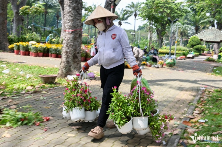 Gần 12h, sau khi có thông báo đóng cửa chợ hoa, nhiều tiểu thương nhanh chóng dọn hàng ra vỉa hè hoặc cố nán lại để bán lấy vốn.