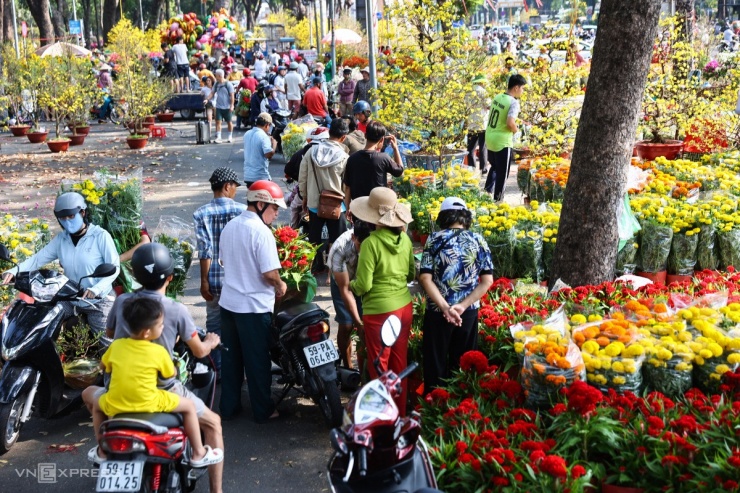 Xe máy, ba gác liên tục ra vào công viên chọn mua hoa. Chợ hoa ở đây mở gần hai tuần, nhưng thường nhộn nhịp vào ba ngày trước thời điểm Giao thừa.