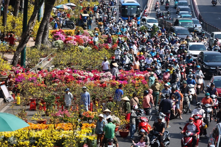 Nhiều thời điểm, đường Hoàng Minh Giám ùn tắc cục bộ vì lượng khách mua hoa quá đông. Nhiều người dừng ngay lòng đường để xem, mặc cả giá bán hoa "xổ" ngày 29 Tết.