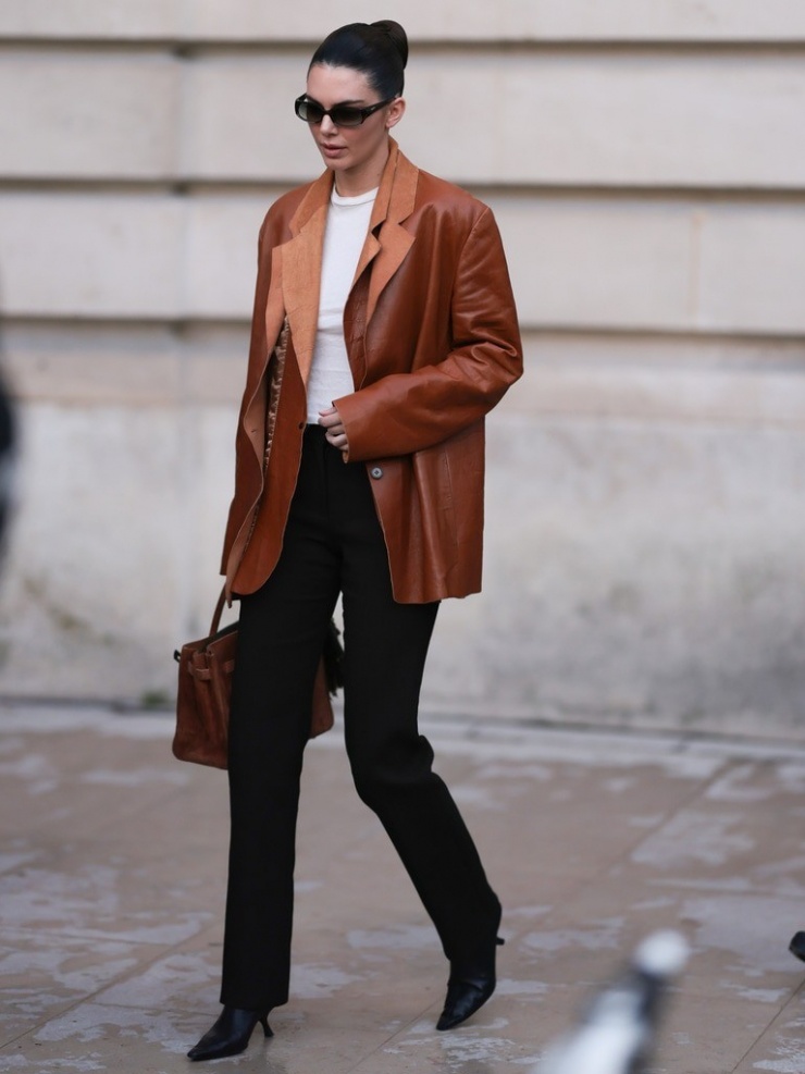 Ở show Schiaparelli, Kendall Jenner chọn phong cách đơn giản, sang trọng với blazer da thuộc, túi Birkin thay vì váy áo gợi cảm như thường lệ.