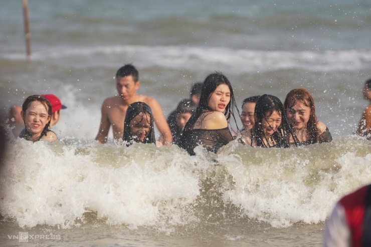 Nhóm bạn trẻ từ Bình Dương thích thú đón những đợt sóng lớn dạt vào bờ. "Tôi mất 4 giờ để đến được Vũng Tàu, đường khá đông, kẹt xe kéo dài ở đoạn qua Đồng Nai, nhưng đến đây tất cả mệt mỏi được xả", Ly, thành viên nhóm nói.