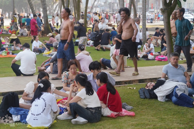 Nhiều gia đình mang theo bạt trải ngồi, nằm trong công viên sát quảng trường cột cờ.