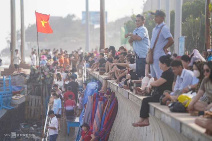 Hàng nghìn lượt du khách từ các khách sạn trên đường Thùy Vân đổ ra bờ kè bãi biển hóng mát về chiều. Nhiều người e ngại xuống tắm do sóng lớn, nước biển khá lạnh.