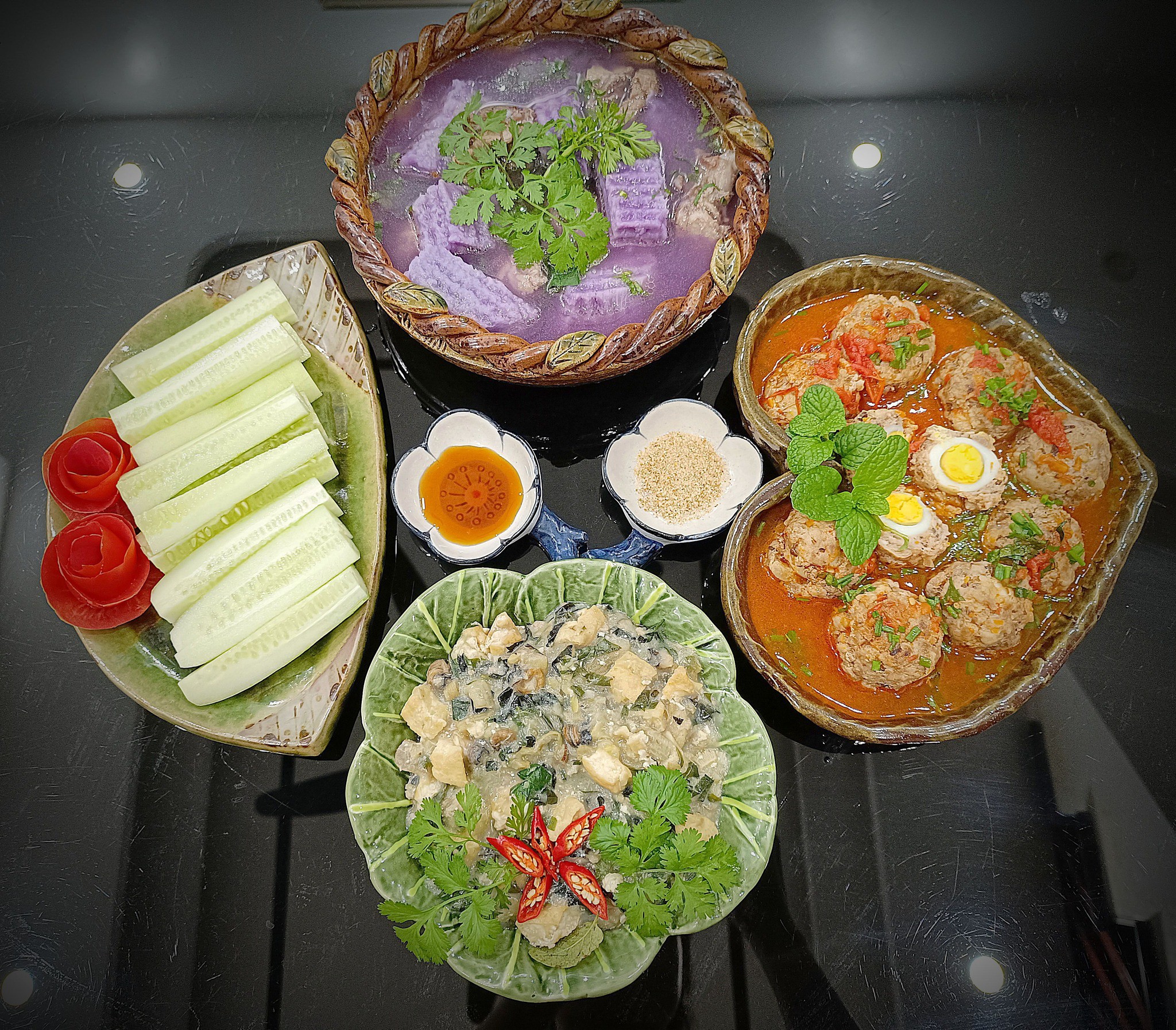 Dưa chuột, canh củ từ tím ninh xương, thịt bọc trứng cút sốt cà chua, ốc chuối đậu dầm.