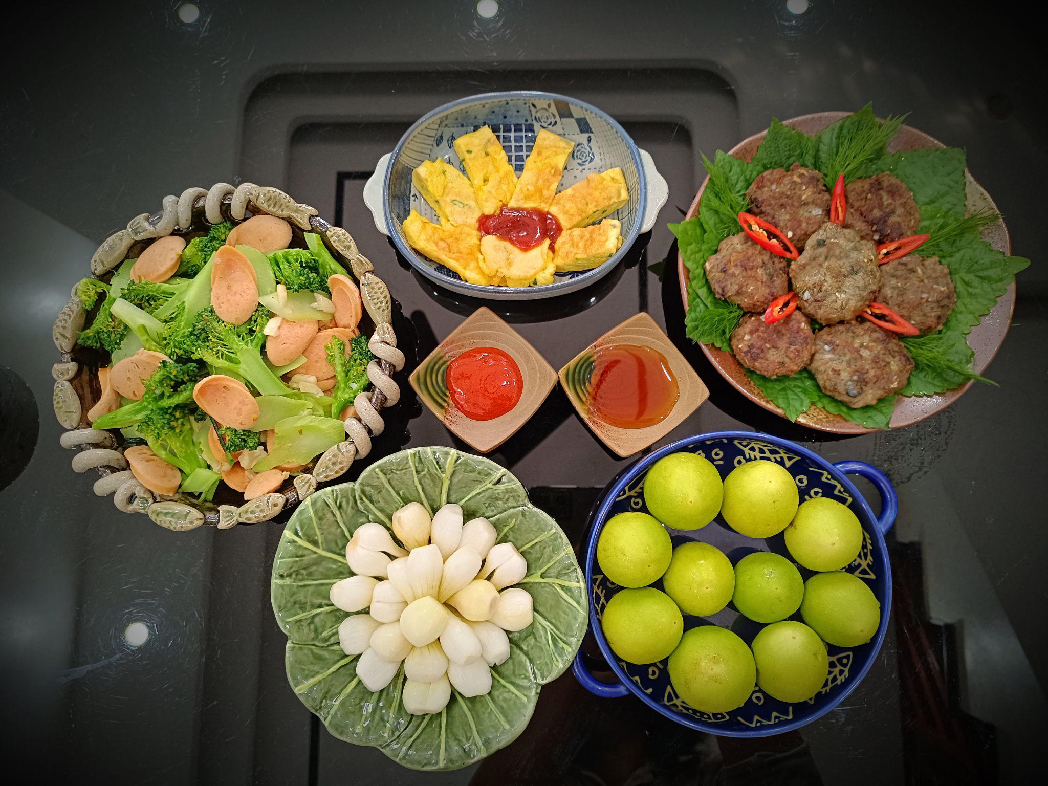 Dưa hành, Súp lơ xào xúc xích, trứng tráng, chả cả mòi, táo.