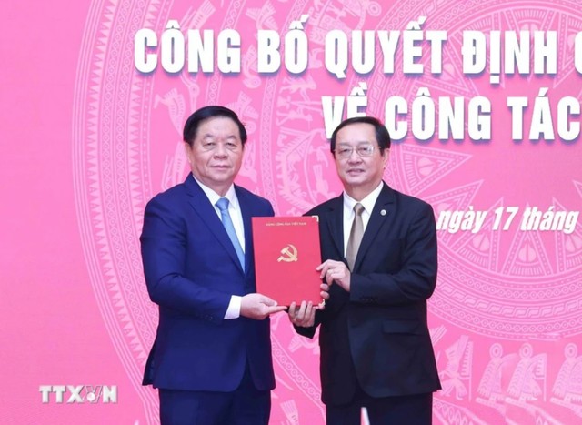 Ủy viên Bộ Chính trị, Bí thư Trung ương Đảng, Trưởng Ban Tuyên giáo và Dân vận Trung ương Nguyễn Trọng Nghĩa (bên trái) trao Quyết định của Bộ Chính trị cho ông Huỳnh Thành Đạt. Ảnh: TTXVN