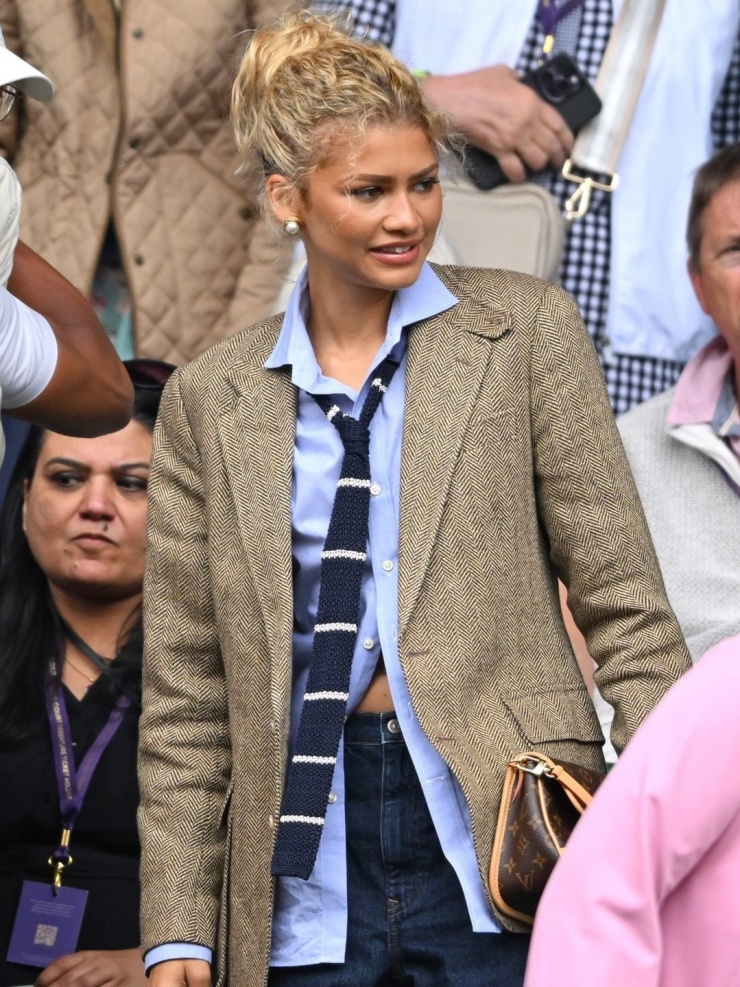 Zendaya dùng khăn len mảnh làm cà vạt, tô điểm cho bộ trang phục công sở gồm sơ mi xanh dương, blazer và quần jeans. Ảnh: GC Images