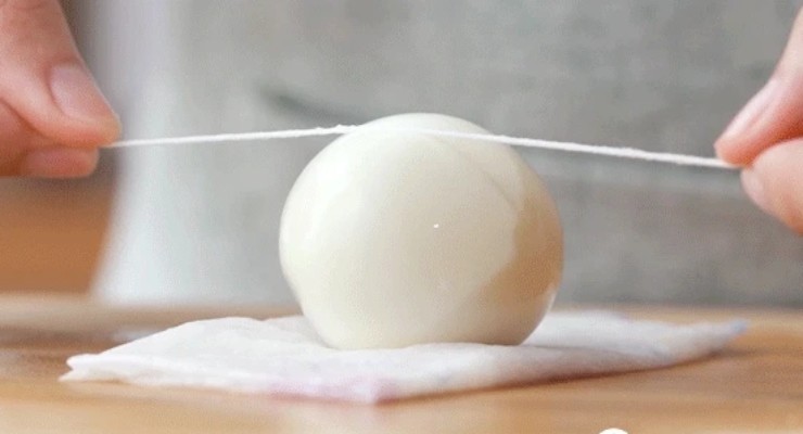 Ngâm trứng vào nước lạnh khoảng 5 phút, sau đó bóc vỏ. Dùng dây chỉ mảnh hoặc dao sắc cắt trứng thành từng miếng dày 1cm.