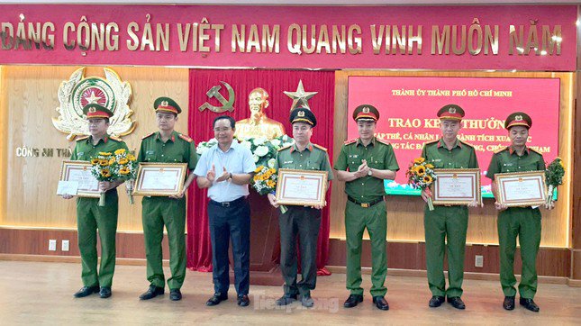 Ông Được và Thiếu tướng Mai Hoàng, Phó giám đốc Công an TPHCM trao khen thưởng cho các tập thể và cá nhân có thành tích xuất sắc. Ảnh: Hoàng Thuận.