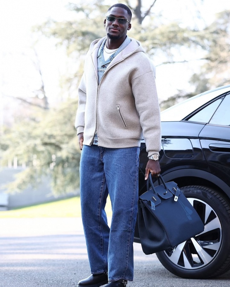 Trung vệ Ibrahima Konaté (Liverpool) phối layer ba lớp áo với quần denim, giày da và túi Birkin cỡ đại của Hermès. Vài năm nay, anh được mệnh danh là "ngôi sao thời trang mới nổi của tuyển Pháp", "phối đồ như siêu mẫu".