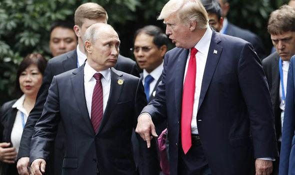 Tổng thống Mỹ Donald Trump và người đồng cấp Nga Vladimir Putin nói chuyện khi đi bộ cùng nhau để chụp ảnh kỷ niệm tại Hội nghị cấp cao APEC. Ảnh: Daily Express