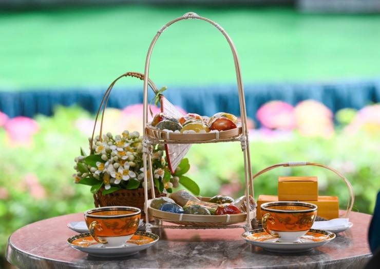 Hai phu nhân thưởng thức trà sen và các món bánh cổ truyền như bánh cốm, bánh xu xê.