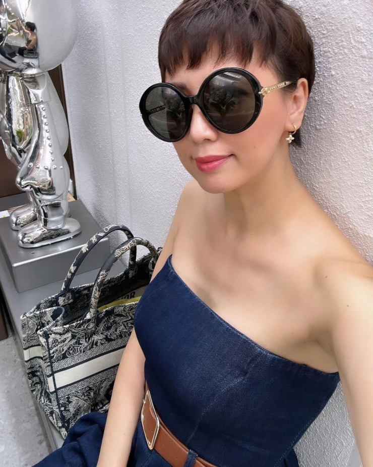 Jumpsuit chất liệu denim dáng quây đem lại hình ảnh năng động và giúp Mai Đoàn tôn vai trần mong manh. Bà tô điểm vẻ ngoài bằng kính râm Gucci bản lớn và bông tai Louis Vuitton nhỏ xinh.