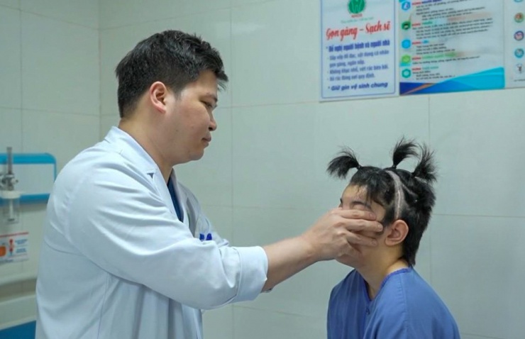 Bác sĩ thăm khám bệnh nhân bị dị tật sọ mặt.
