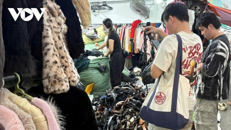 Các bạn trẻ chụp ảnh trang phục tại một sạp hàng ở chợ Đông Tác để tham khảo ý kiến bạn bè. (Ảnh: Nhã Linh)