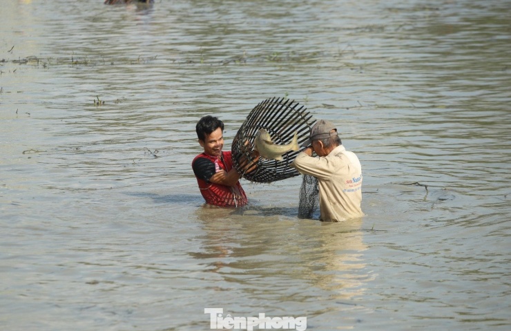 "Nơm thủ" bắt được con cá lớn liền khoe với mọi người. (Ảnh: Rạng Đông).