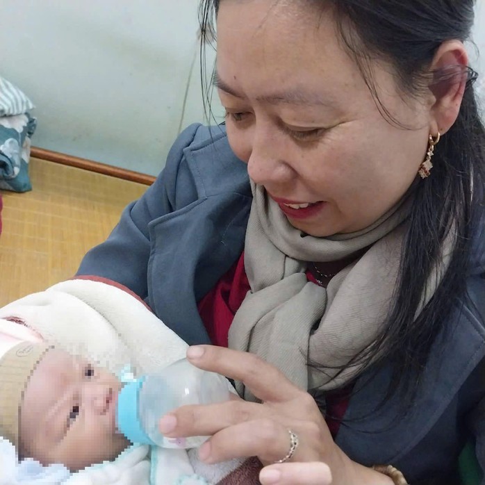 Bé trai được quấn trong áo ấm, kèm theo quần áo đặt trong một túi ni-lông