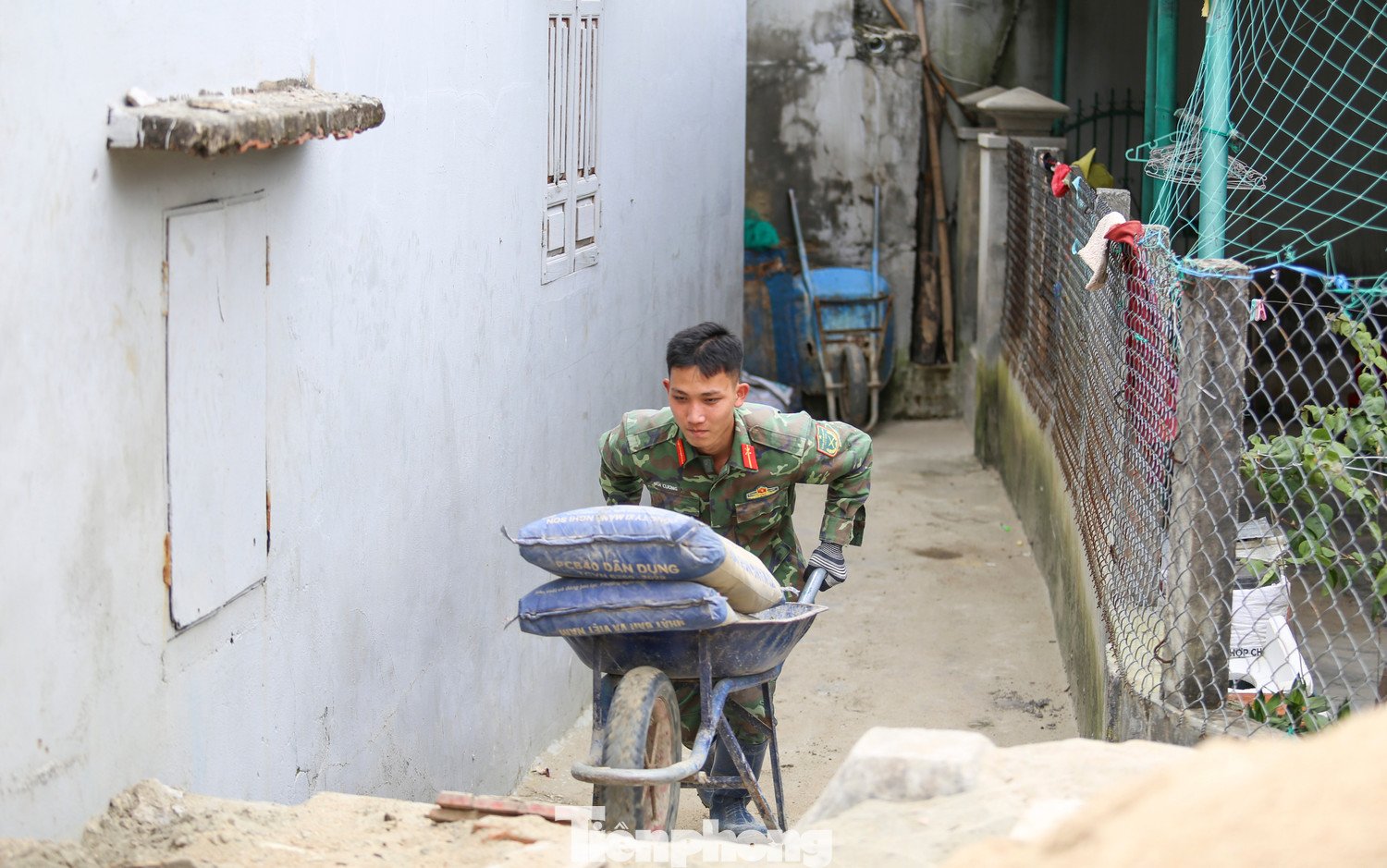 Nhờ sự hỗ trợ tận tình của các chiến sĩ bộ đội trong việc vận chuyển vật liệu, gia đình chị Ngô Thị Mỹ Nhung (38 tuổi, xóm Cồn Chim) mới có thể từng bước dựng lại ngôi nhà bị bão đánh sập. Chị Nhung cho biết, ngoài 60 triệu đồng được Nhà nước hỗ trợ và sự giúp đỡ của người thân, nhà hảo tâm, chính sự chung tay của bộ đội đã giúp gia đình giảm gánh nặng chi phí, sớm có điều kiện ổn định chỗ ở. “Nếu phải thuê vận chuyển bên ngoài, chi phí sẽ tăng lên rất nhiều”, chị chia sẻ. Ảnh: Trương Định