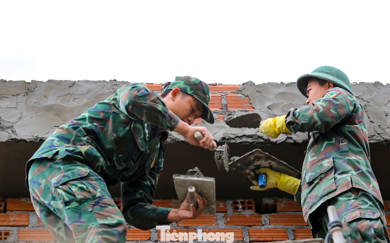 Bộ đội hỗ trợ xây nhà cho người dân sau thiên tai. Ảnh: Trương Định