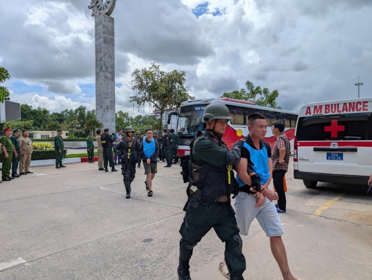 Cảnh sát dẫn giải các đối tượng lên xe để đưa về Việt Nam từ cửa khẩu Campuchia