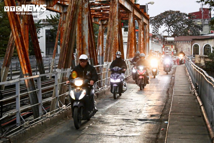 Người Hà Nội khoác áo mưa ra đường từ tờ mờ sáng trong gió rét đầu năm - 4