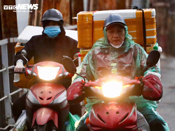 Người Hà Nội khoác áo mưa ra đường từ tờ mờ sáng trong gió rét đầu năm - 5