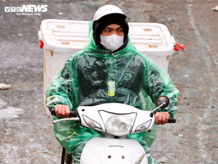 Người Hà Nội khoác áo mưa ra đường từ tờ mờ sáng trong gió rét đầu năm - 8