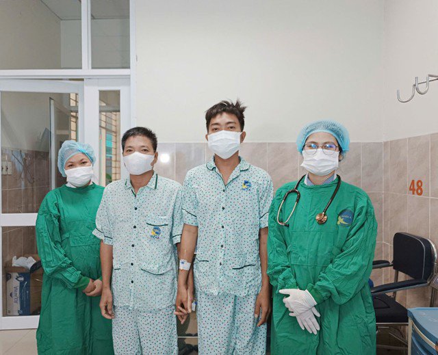 Hai bố con anh Đ. và các bác sĩ điều trị vui mừng trước ngày xuất viện. Ảnh: Báo Tin tức