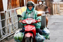 Người Hà Nội khoác áo mưa ra đường từ tờ mờ sáng trong gió rét đầu năm