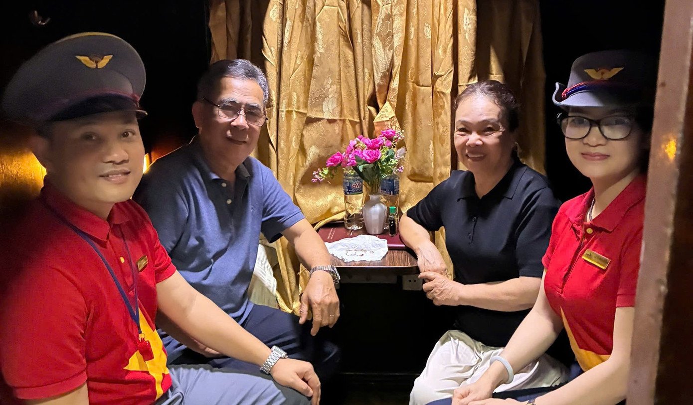 Hành khách và tổ tiếp viên tàu SE5 sau khi tìm được gói vàng được bọc trong giấy ăn bỏ nhầm vào thùng rác. Ảnh: VNR.