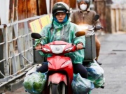 Người Hà Nội khoác áo mưa ra đường từ tờ mờ sáng trong gió rét đầu năm