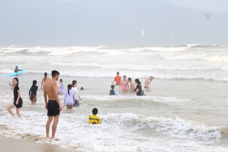 Về chiều, thời tiết se lạnh nhưng người dân và du khách cũng không ngần ngại tắm biển.