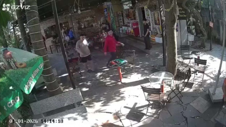 Bình (áo đỏ) thời điểm cầm ly nước đập vào đầu chị C. Ảnh cắt từ clip.