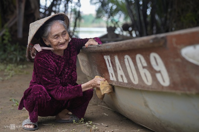 Cụ Xong lau chùi con thuyền do nhiếp ảnh gia Pháp tặng, như cách gìn giữ ký ức. Ảnh: Nguyễn Đông