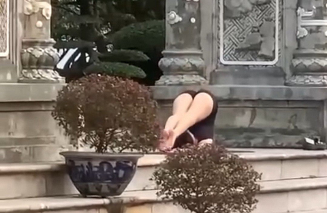 Cô gái tập các động tác "kém duyên" ở chốn chùa chiền.