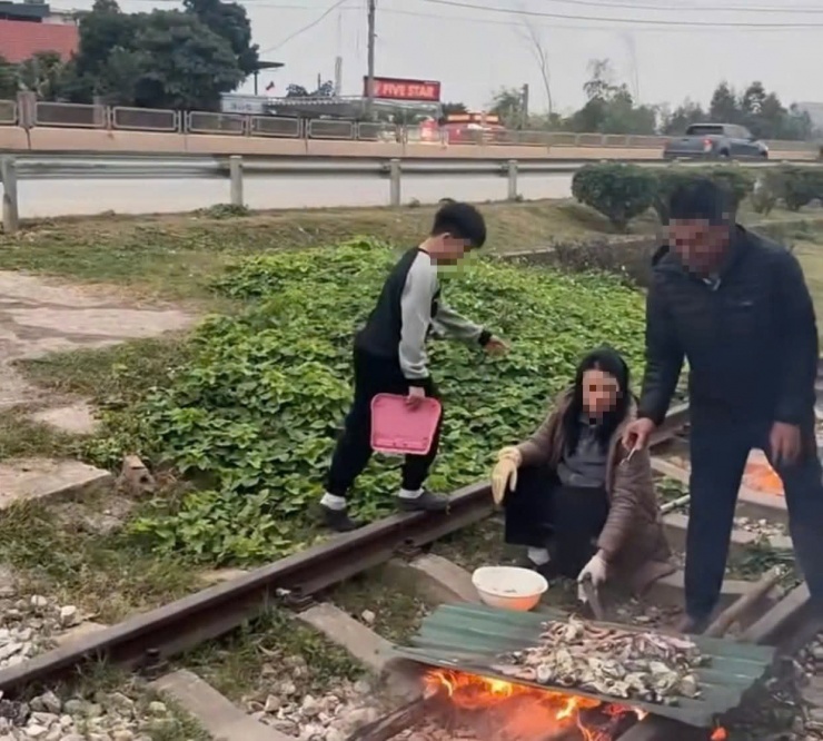 Ông N.V.Y cùng vợ nướng đồ ăn trên đường ray trước khu vực sinh sống.