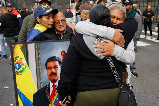 Những người ủng hộ Tổng thống Venezuela Nicolás Maduro ôm nhau giữa trung tâm thủ đô Caracas. Ảnh: AP
