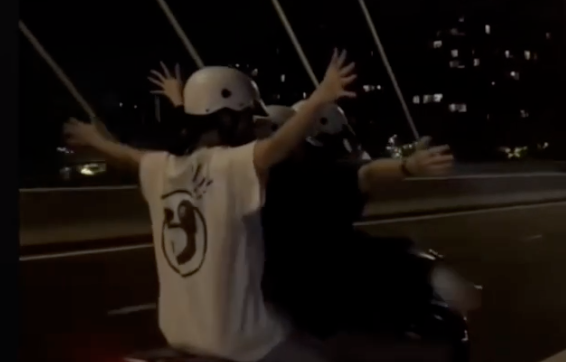 Cả ba thanh thiếu niên buông tay khi chạy xe máy.