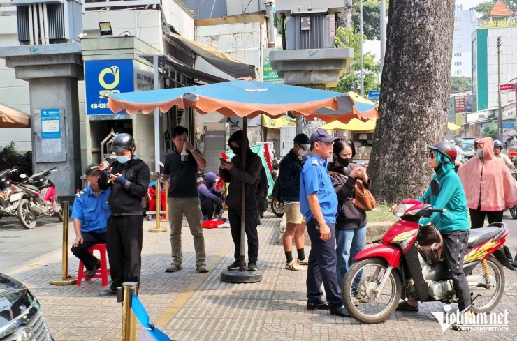 Bất chấp trưa nắng, người dân vẫn chờ đợi bên ngoài SJC để đăng ký mua vàng miếng trực tuyến. Ảnh: Trần Chung