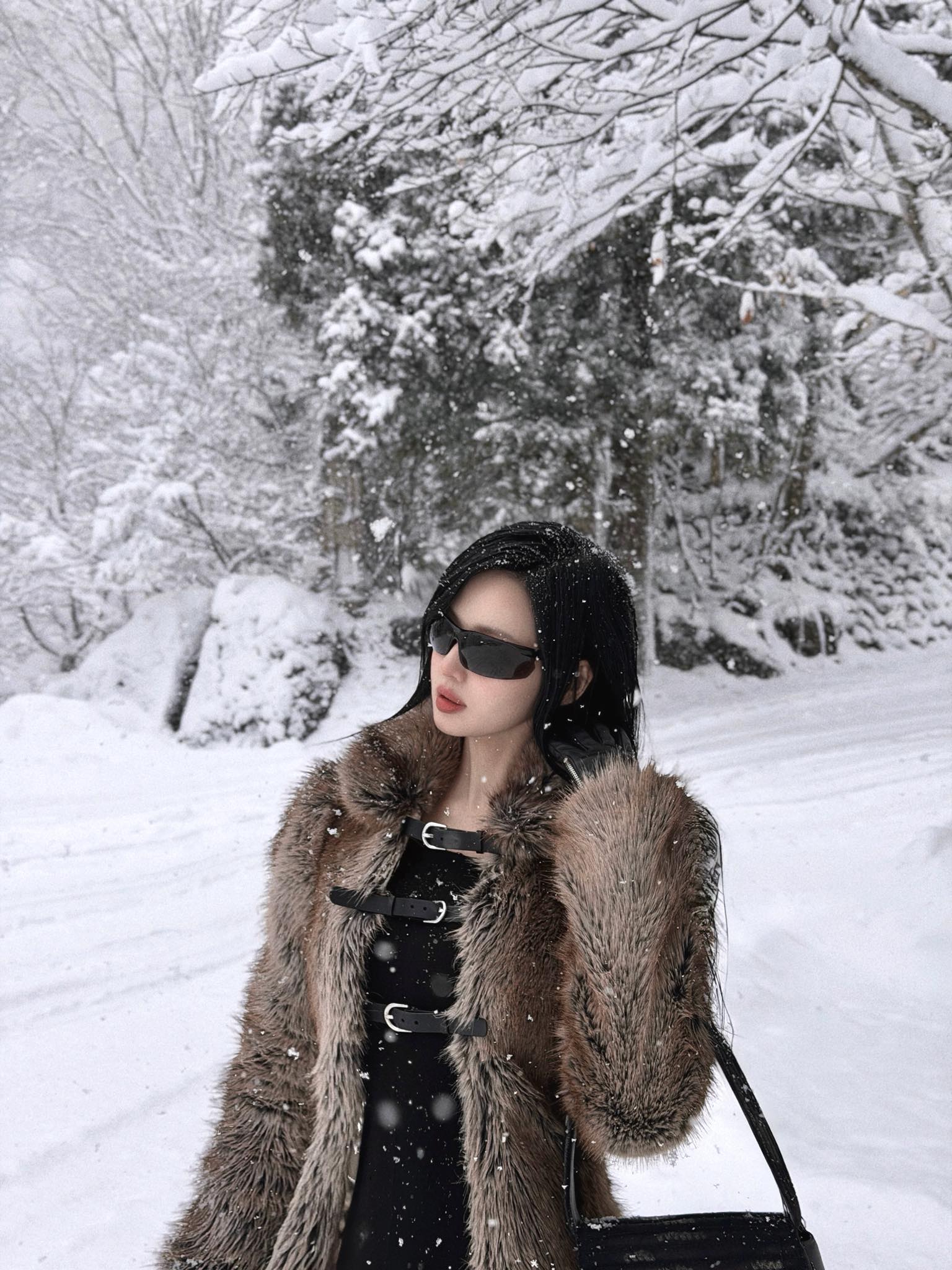 Đi ngắm tuyết trắng ở Nhật Bản, Tâm Tít diện phong cách sang chảnh với áo lông dài chấm đất. Bên trong cô phối cả 'cây' đồ đen cool ngầu.