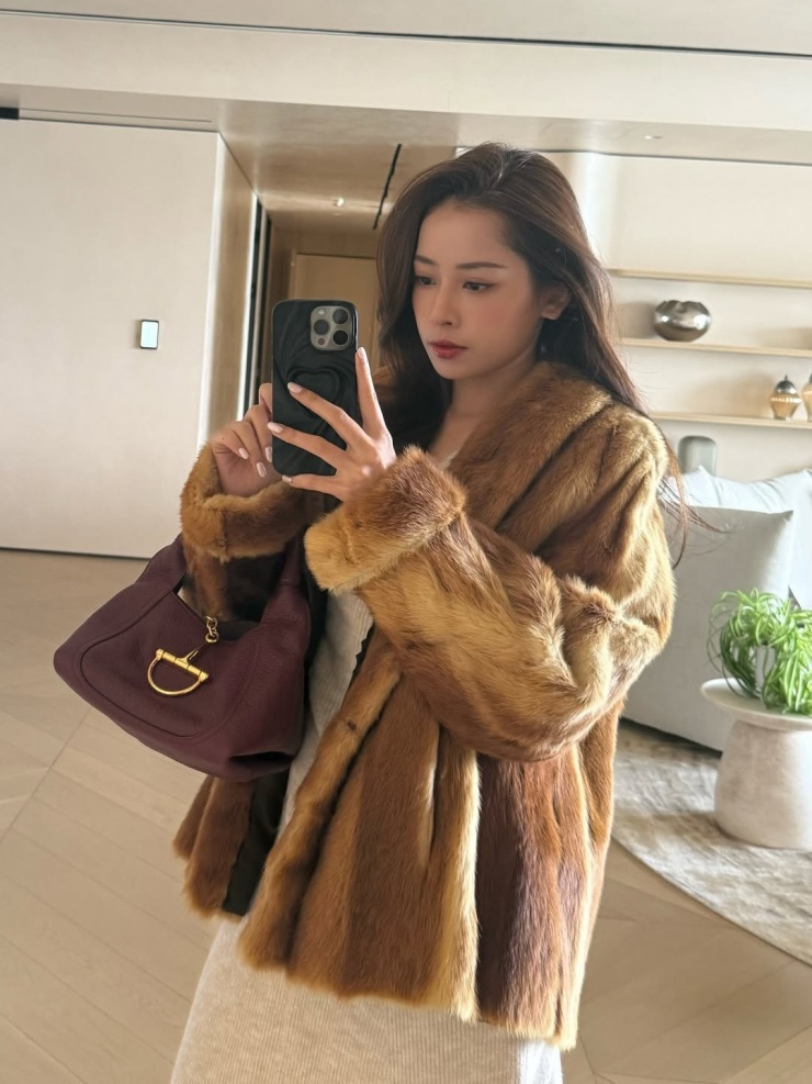 Cũng trong chuyến đi này, cô diện áo lông thú tông nâu chuyển màu, xách túi Gucci.