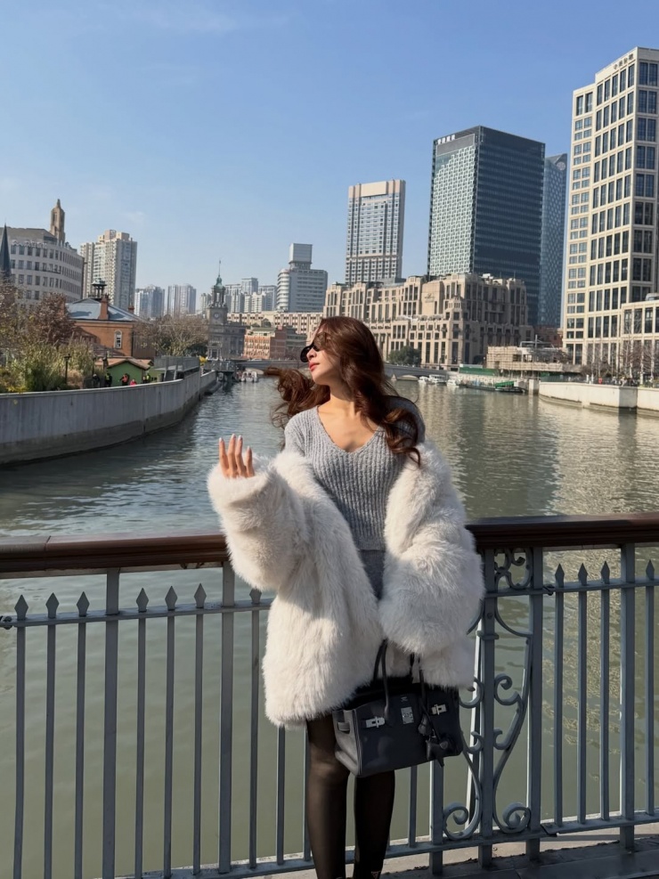 Trong chuyến đi chơi đầu năm mới ở Thượng Hải, Chi Pu khoác áo lông trắng ngoài bộ váy áo len mỏng, tăng vẻ sang trọng bằng túi Birkin của Hermes.